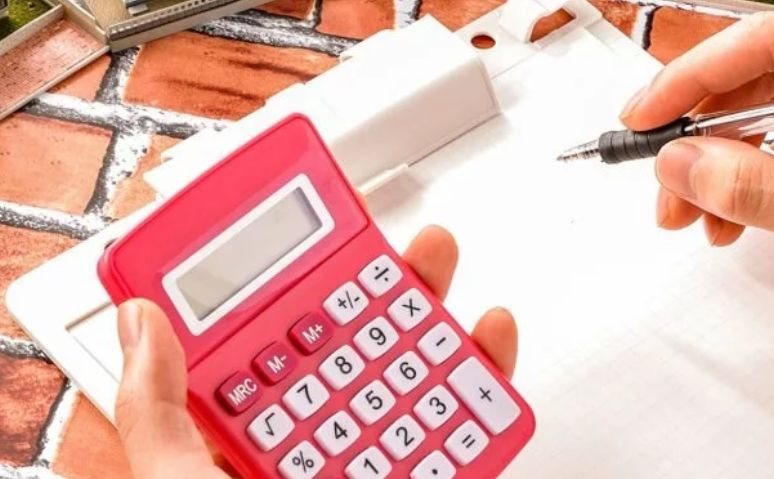 Девушка рассчитывает стоимость услуги на калькуляторе
